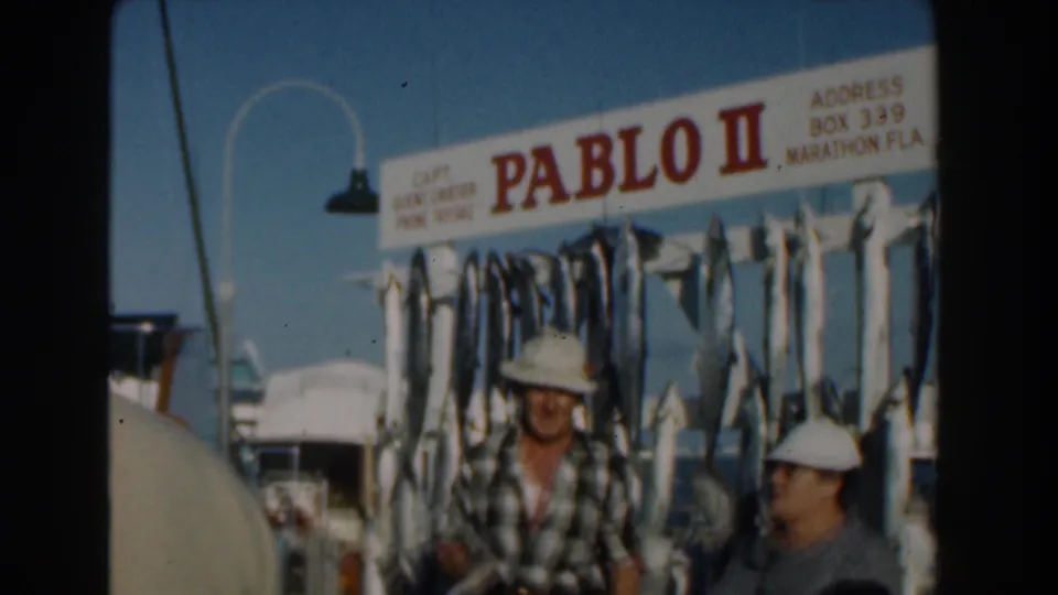 Three adults appear near the Pablo II sign and hanging catch on a sunny fishing boat deck, with Marathon, Fla. visible on the sign.