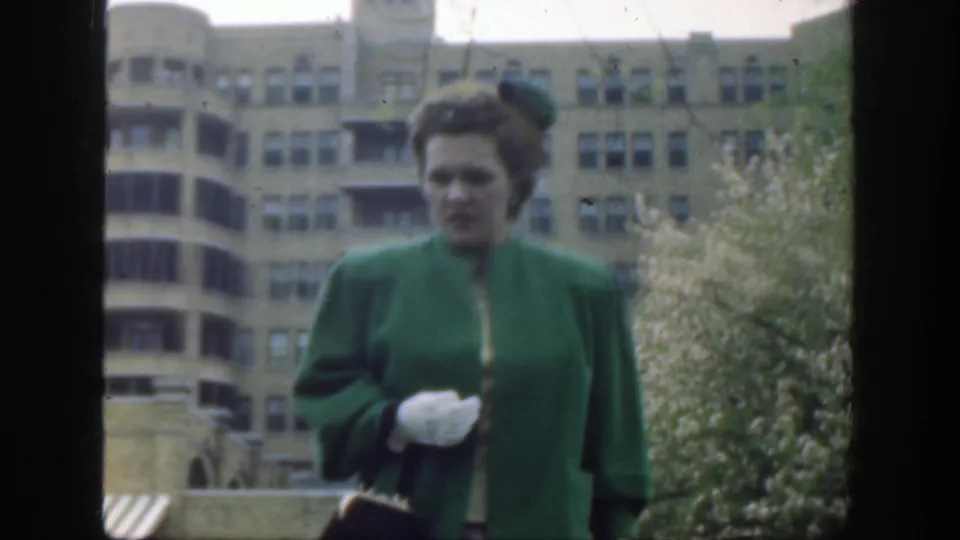 A closer 1949 Cincinnati frame shows the woman in a green coat, hat, and white gloves moving toward the camera.