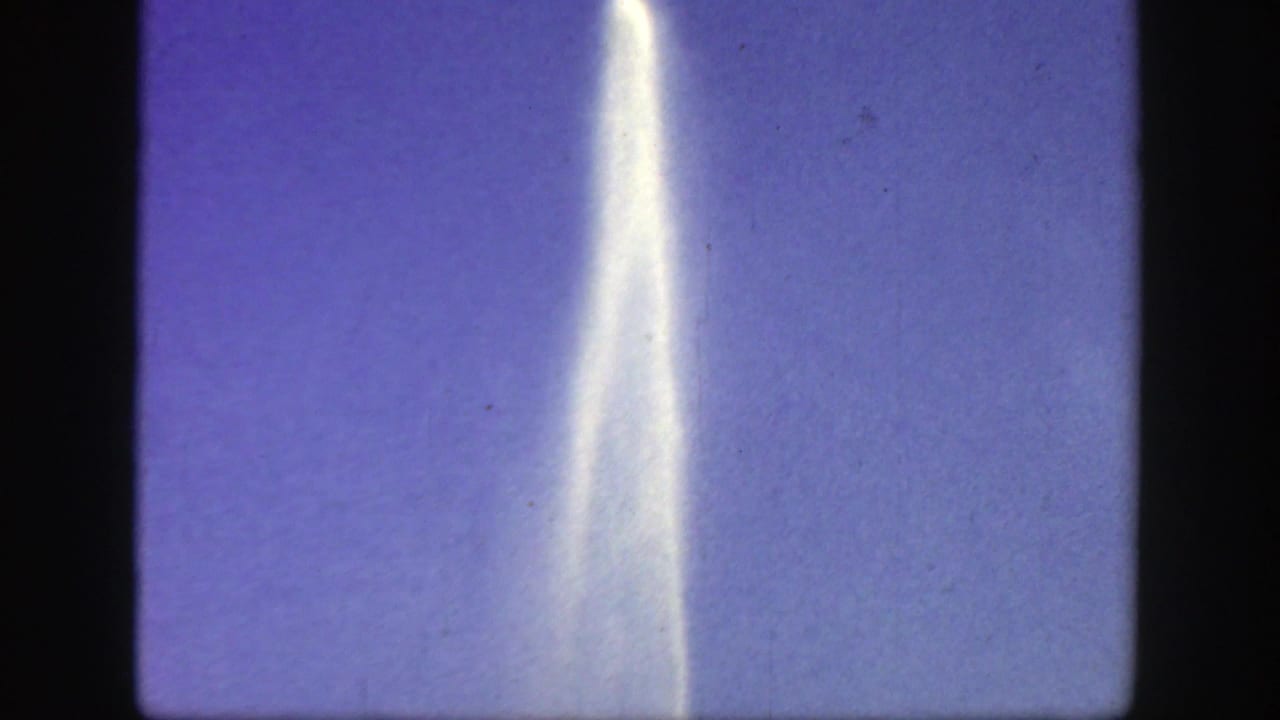 Narrow fountain plume reaching upward against a mostly clear purple-blue sky.