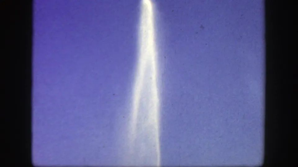 1949 Cincinnati frame with a slender fountain plume extending upward against open sky in soft 8mm color.
