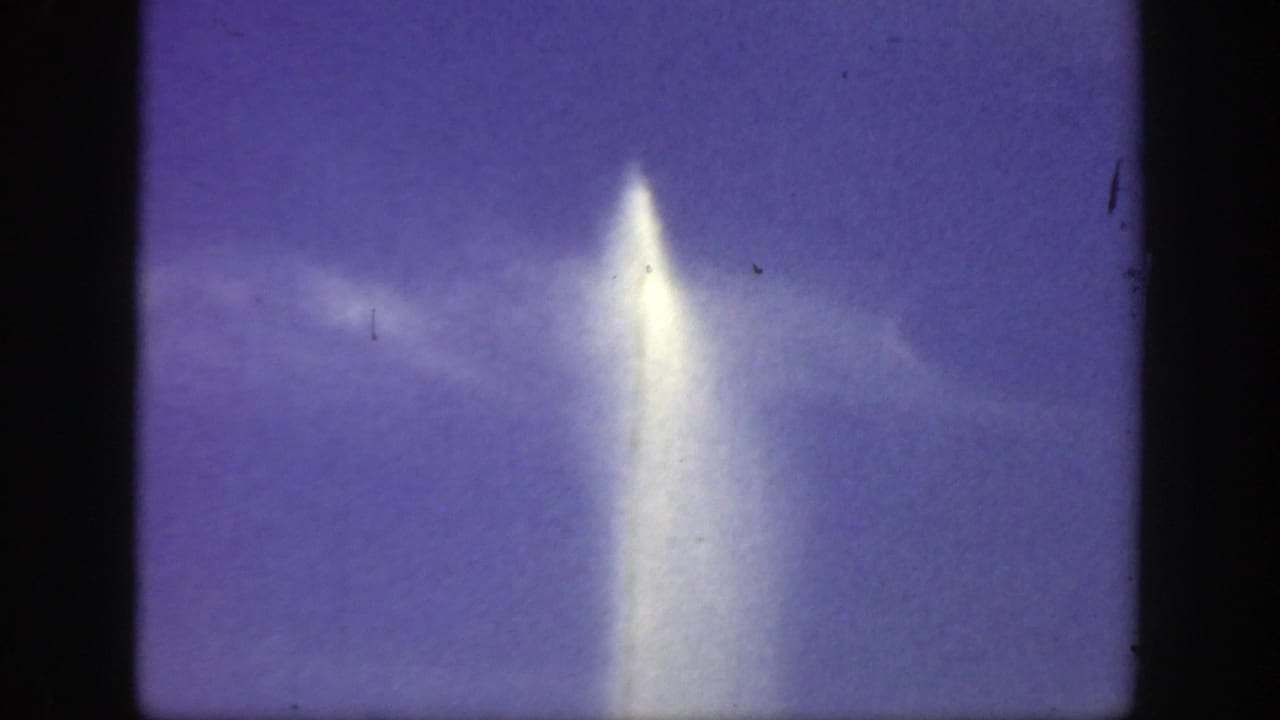 Tall white spray of water against a blue-purple sky with soft cloud streaks.
