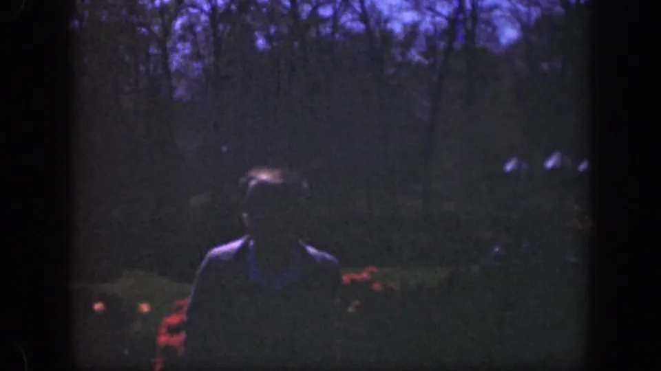 Near the end of the clip, the subject is closer to the camera, with facial detail hidden by shadow and grain.