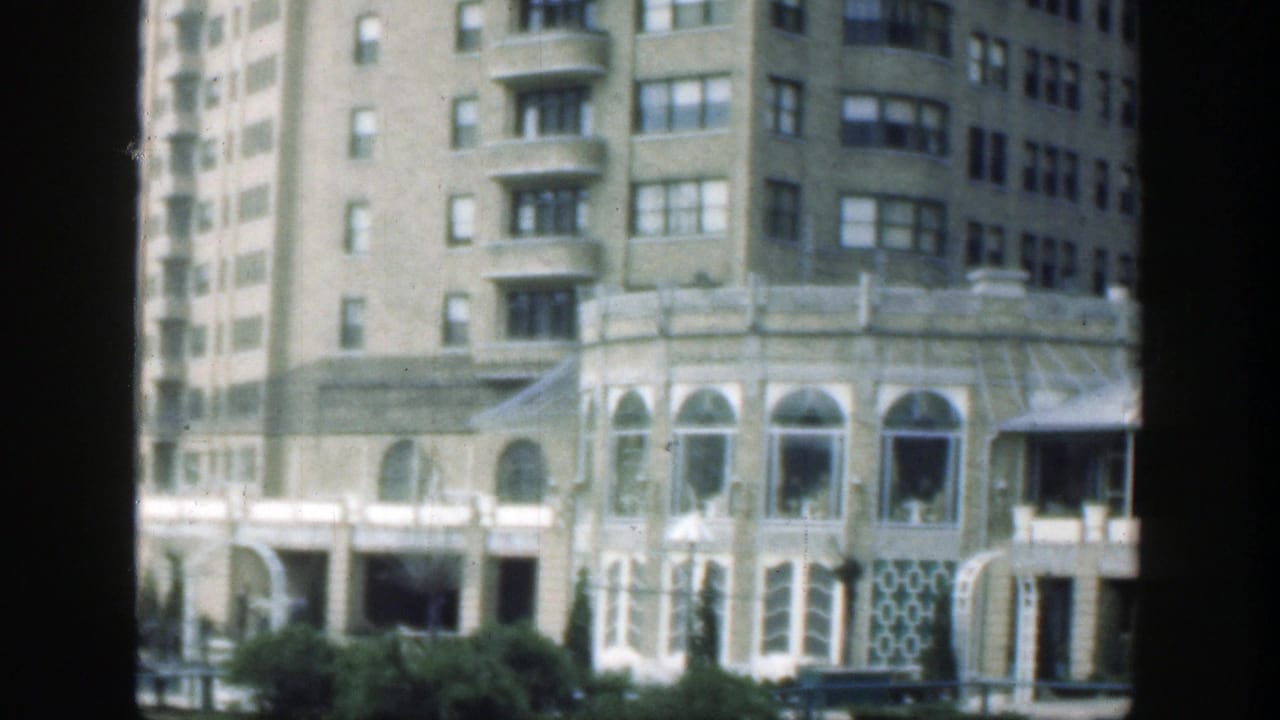 Ornate multi-story building with arched lower windows and landscaping.