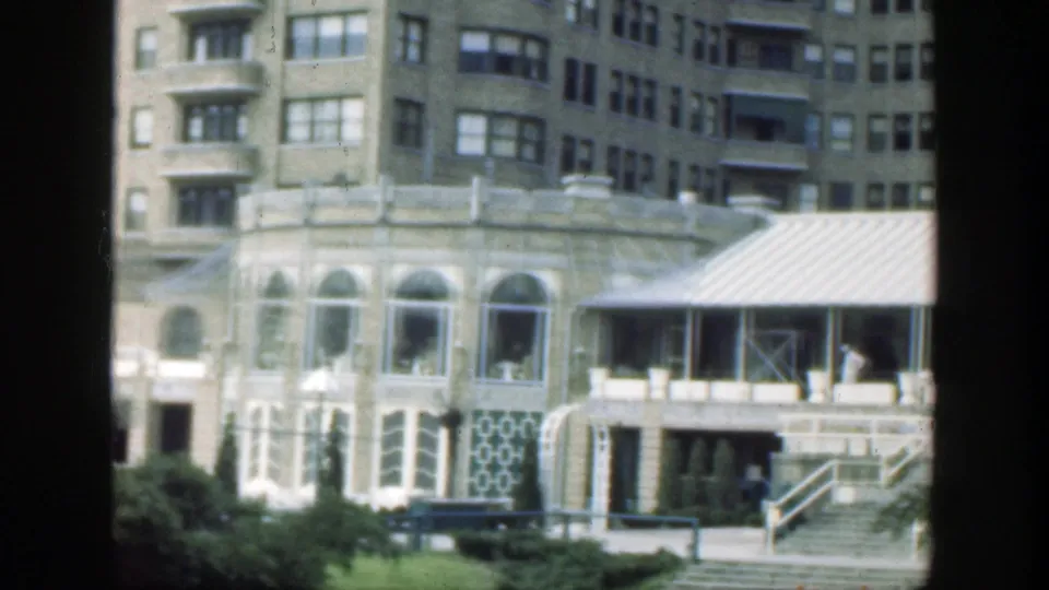 1949 Cincinnati exterior view of a large ornate building with arched windows, patterned panels, a covered awning, and steps leading to the entrance.