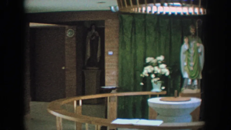 1964 Wisconsin church view showing a doorway, statue niche, green-draped area, flowers, rail, and baptismal font.