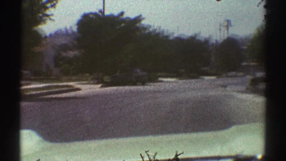 The camera continues forward along a quiet Woodland Hills residential street, with trees and utility poles framing the roadway.
