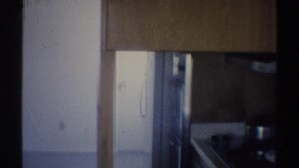 Late-1960s home interior frame with cabinetry, a doorway edge, and a cropped candle-style fixture at the side.
