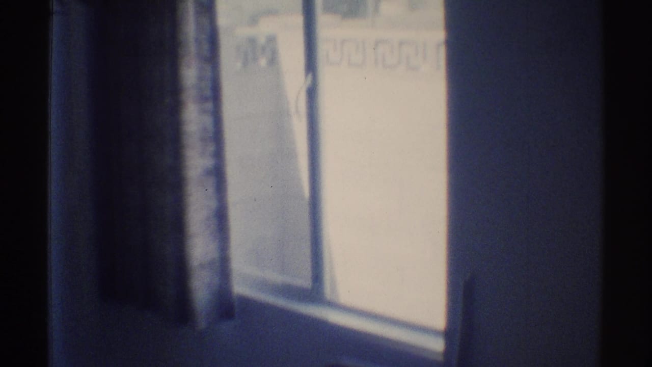 Dim room corner with a bright curtained window and dark wall edges.