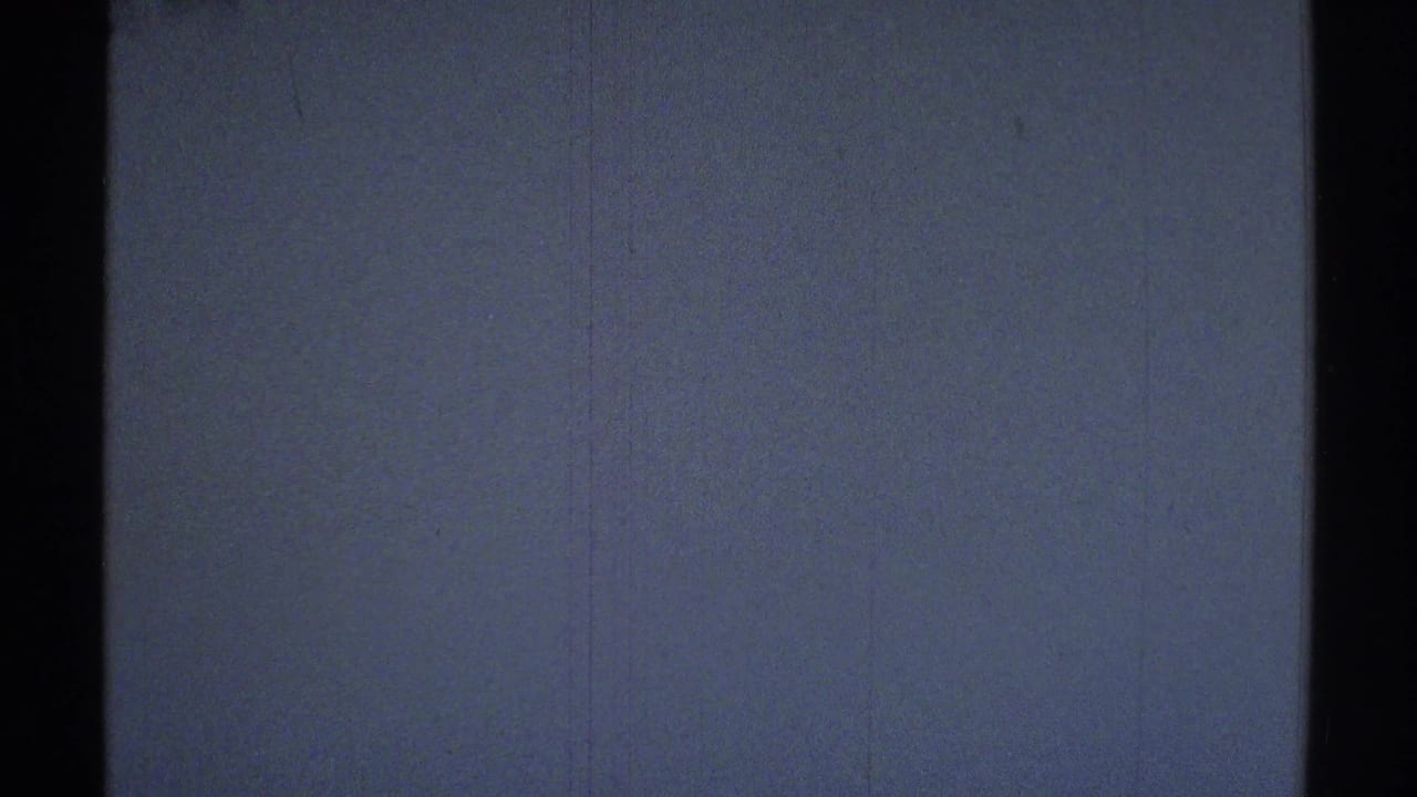 Dim blue-tinted wall with a dark vertical doorway or frame at the right edge.