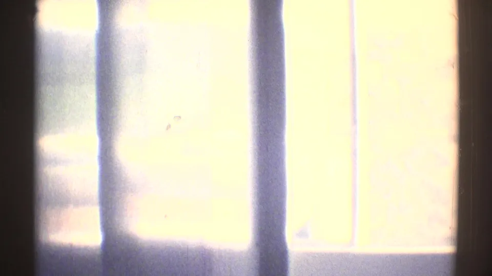 A bright window or doorway area flares the exposure, with vertical lines visible inside the bedroom scene.