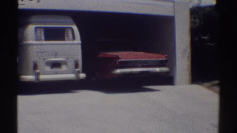 1969 Woodland Hills frame with a white van and red sedan parked side by side in a residential garage.