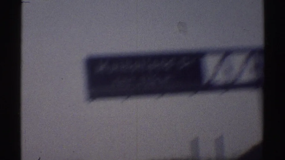 A blurred Mulholland Drive sign appears in 1969 Woodland Hills 8mm footage from a moving car.