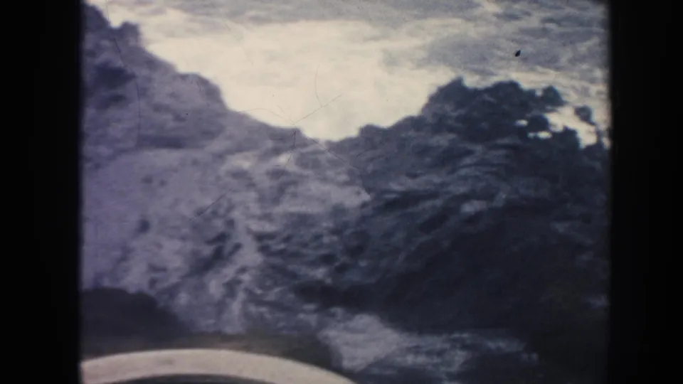 1961 Hawaii 8mm frame that appears to show a rocky coastal or rugged landscape detail with pale sky or water beyond.