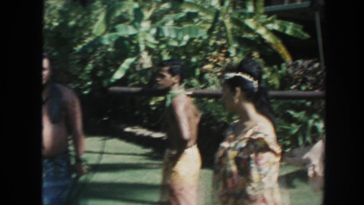 Men walk behind a woman as part of a hog tied to a pole enters the frame.