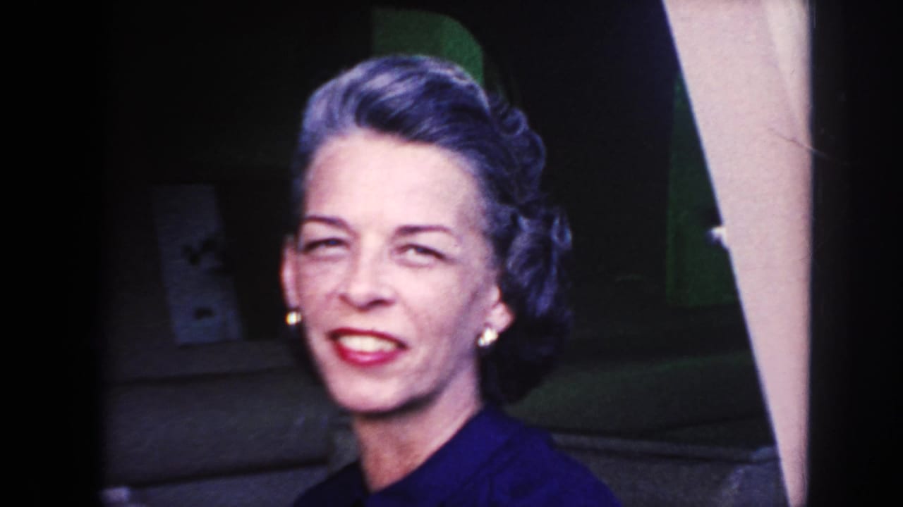 Close view of a smiling woman beside a ship window.