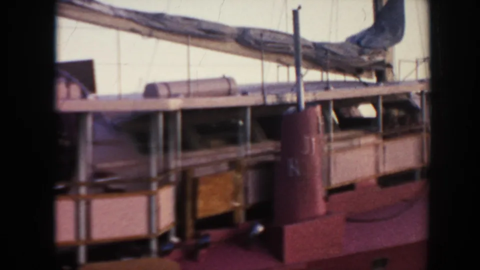1961 Hawaii 8mm close-up of the ship's deck area, showing a red smokestack marked with letters and a boom crossing above.