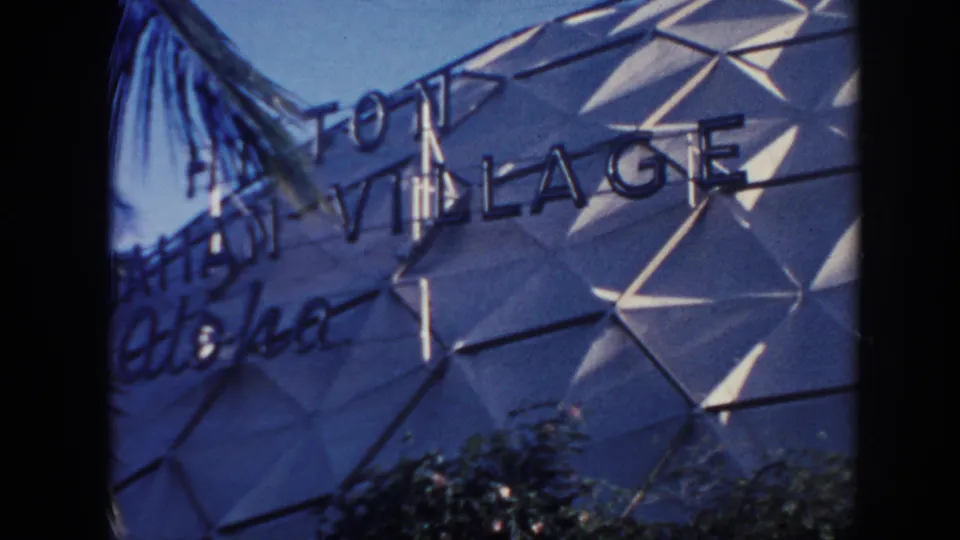 1961 Hawaii 8mm view of the Hilton Hawaiian Village facade with Aloha script and geometric wall panels.