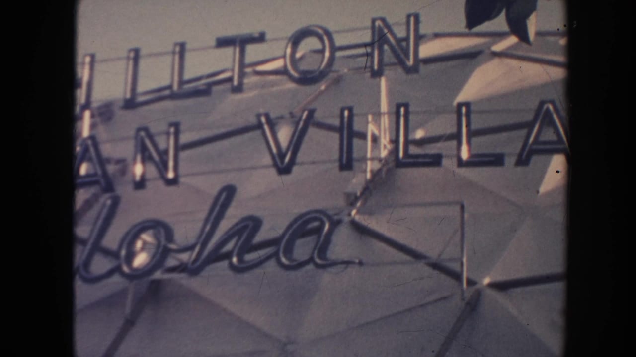 Close view of Hilton Hawaiian Village neon signage with cursive Aloha lettering.