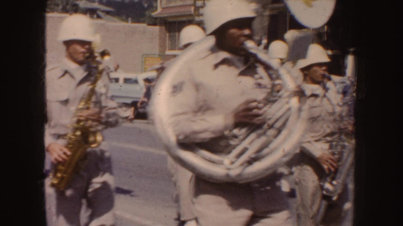 Close curbside view of a sousaphone player and nearby saxophonists during the 1954 South Dakota parade.