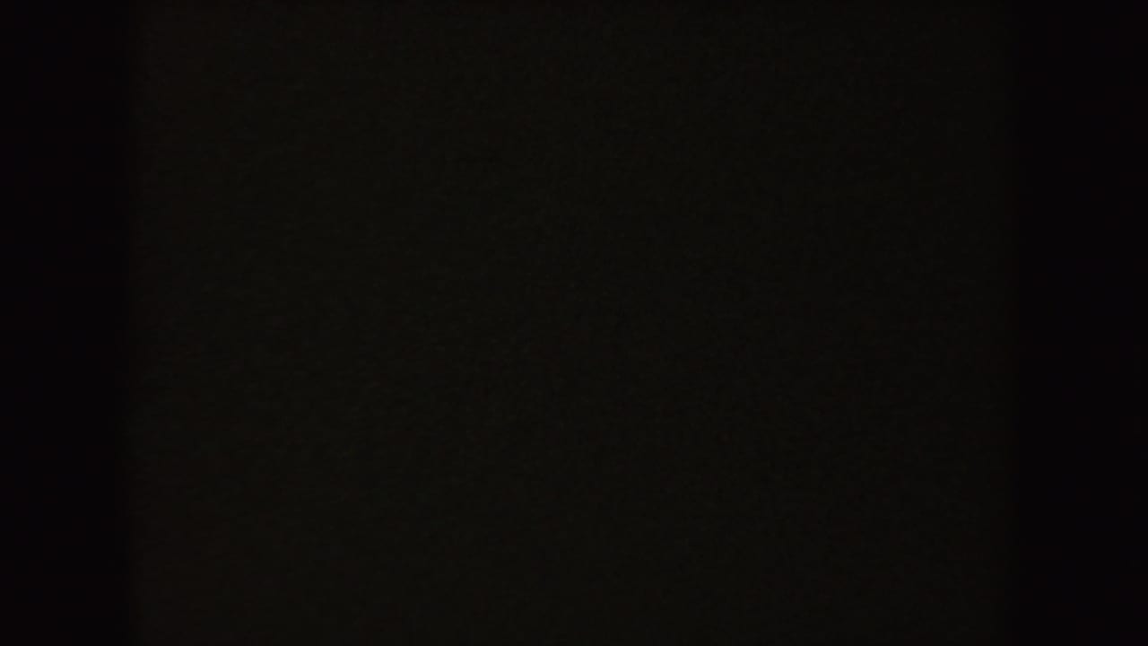 Mostly dark 8mm frame from the 1954 South Dakota home movie, with only faint interior tones visible.