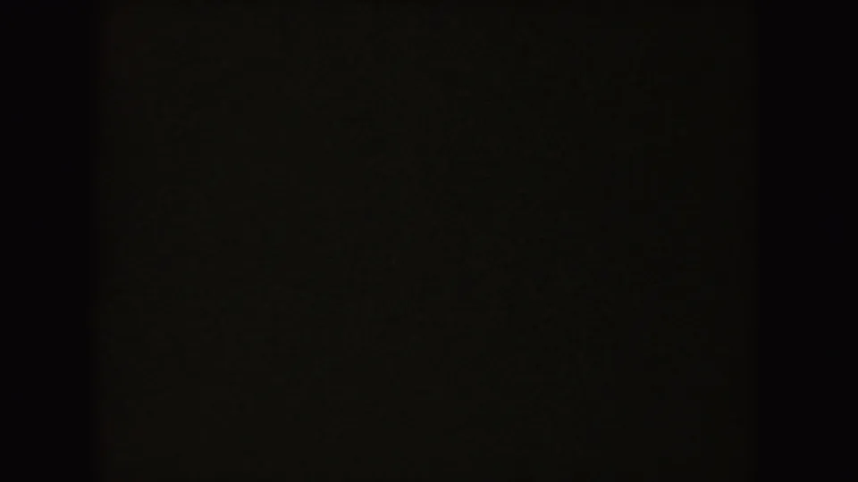 Mostly dark 8mm frame from the 1954 South Dakota home movie, with only faint interior tones visible.