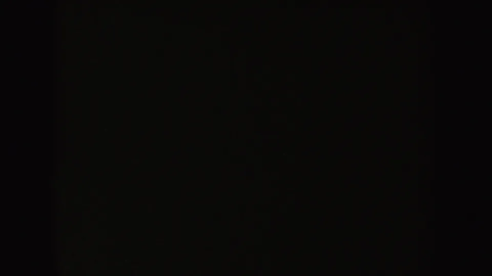 Dark 8mm frame with limited visible detail, likely part of the same indoor holiday scene.