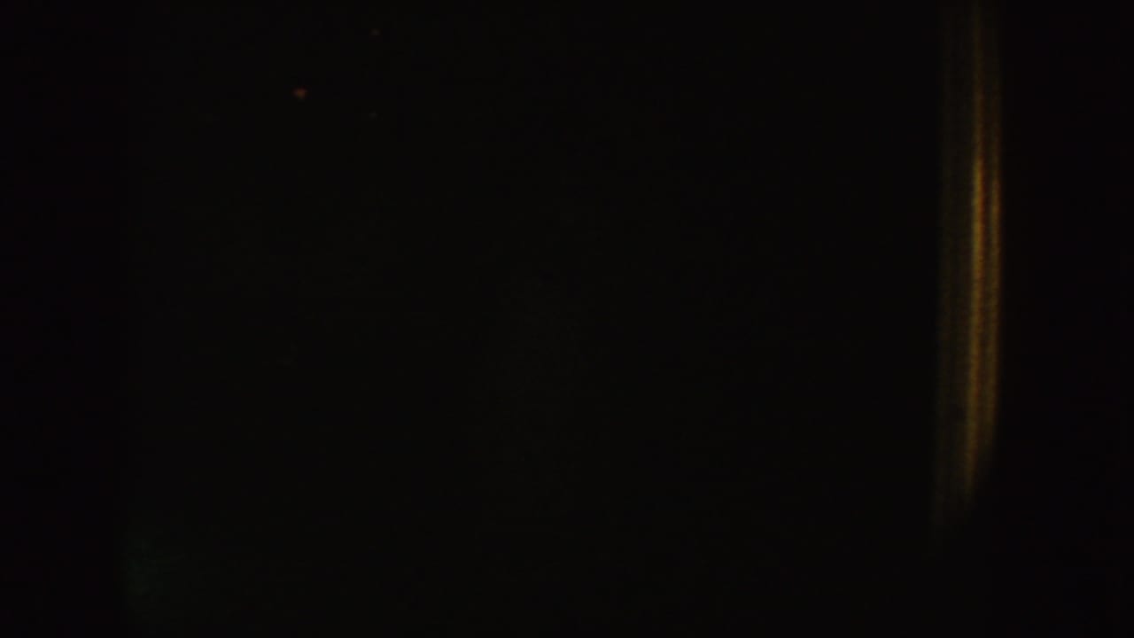 Late frame from the 1954 South Dakota 8mm clip, with most of the view dark and a narrow tan doorway edge at right.