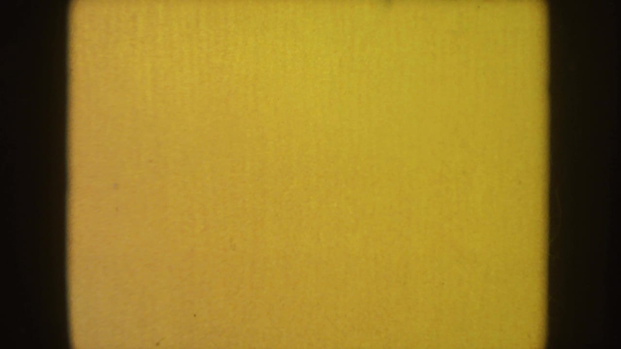 A bright orange-yellow 8mm end frame or leader appears after the dark figure sequence, bordered by black film edges.