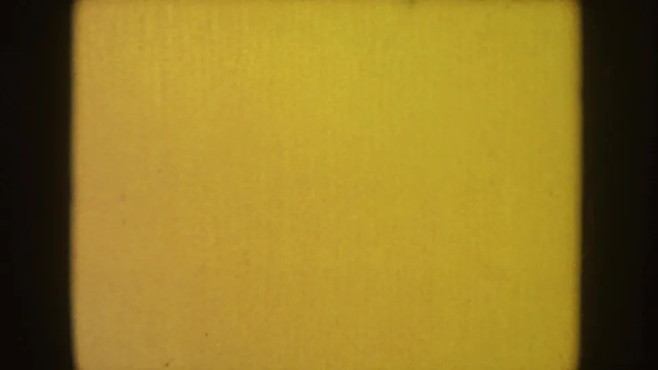 A bright orange-yellow 8mm end frame or leader appears after the dark figure sequence, bordered by black film edges.