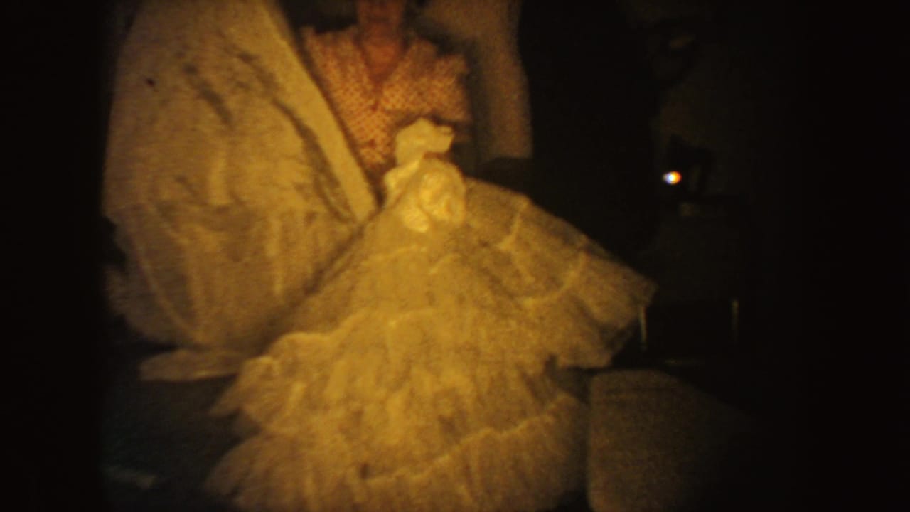 Close view of hands and a full tulle skirt beside a patterned dress.