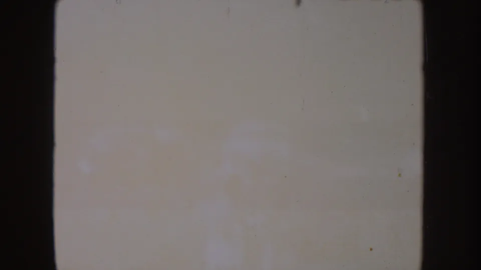 Nearly washed-out 8mm frame from the South Dakota lake clip, with faint shore shapes and visible film deterioration.