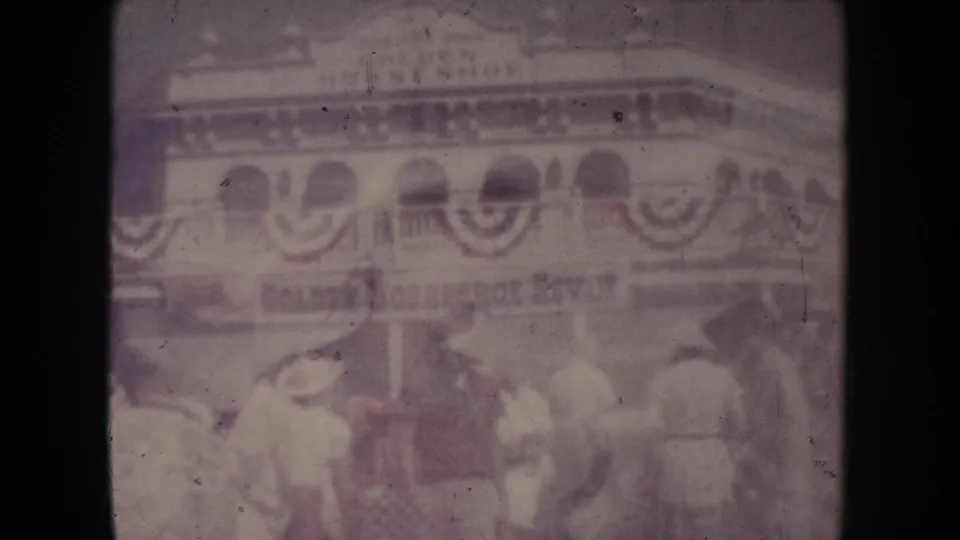 A faded 1954 South Dakota frame layers the bunting-covered building over people in Western-style hats near the storefront.
