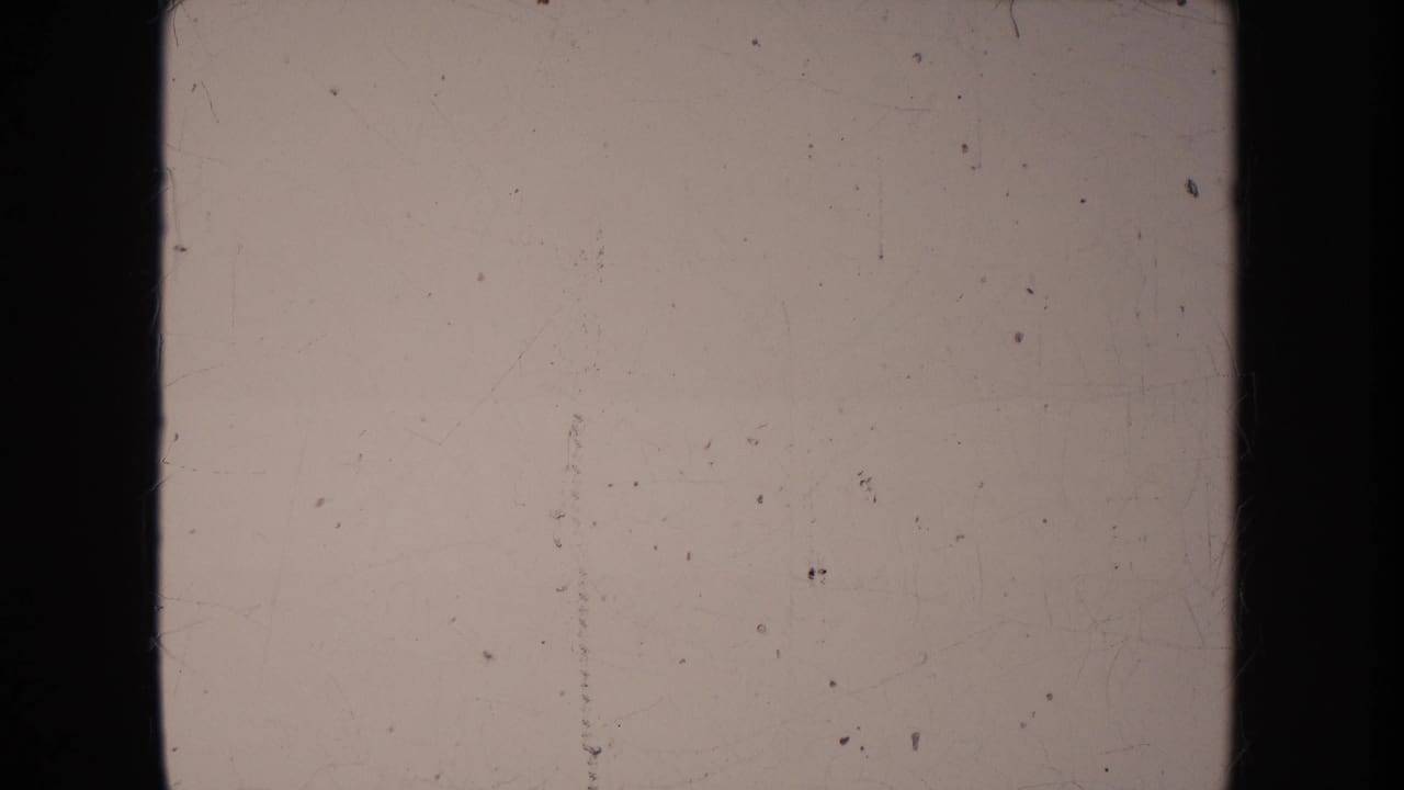 Washed 1950s 8mm frame from the South Dakota clip, dominated by pale exposure and visible physical-film wear.