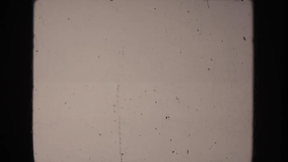 Washed 1950s 8mm frame from the South Dakota clip, dominated by pale exposure and visible physical-film wear.