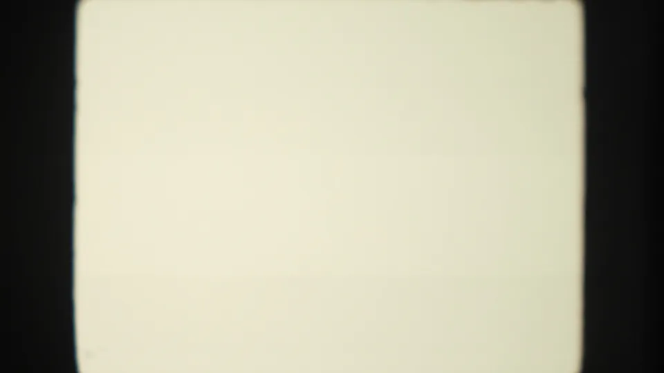 Blank 8mm film leader with pale exposure field, dark gate edges, and no visible scene content.