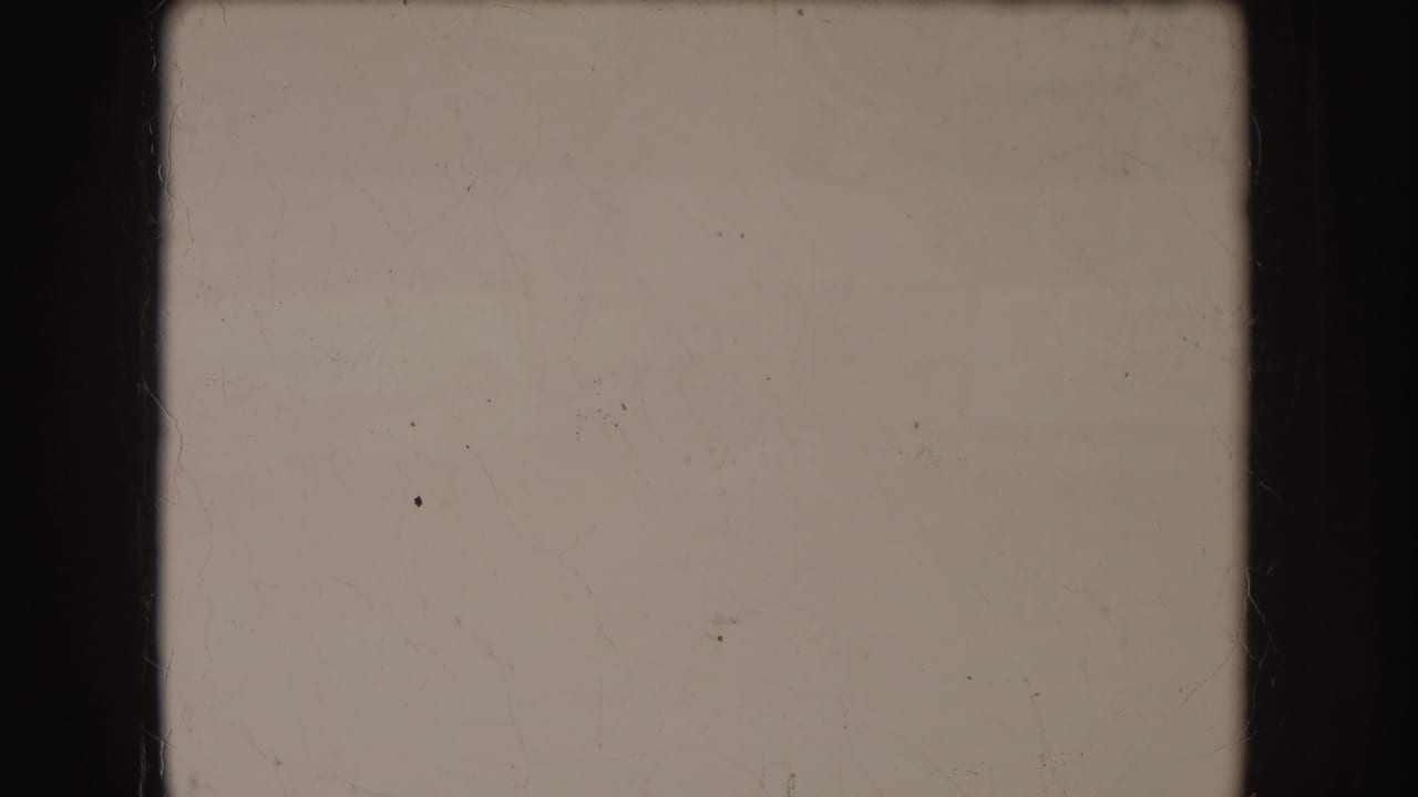 Mostly blank 8mm frame with light exposure, film dust, and no discernible street subject visible.