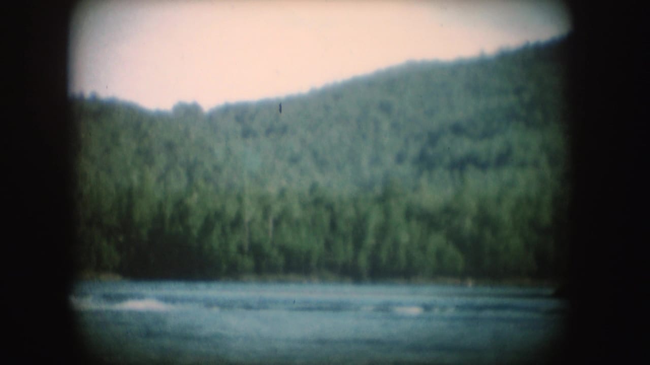 Late frame from the 1954 South Dakota lake sequence, with the boat mostly out of view and wake fading across the water.
