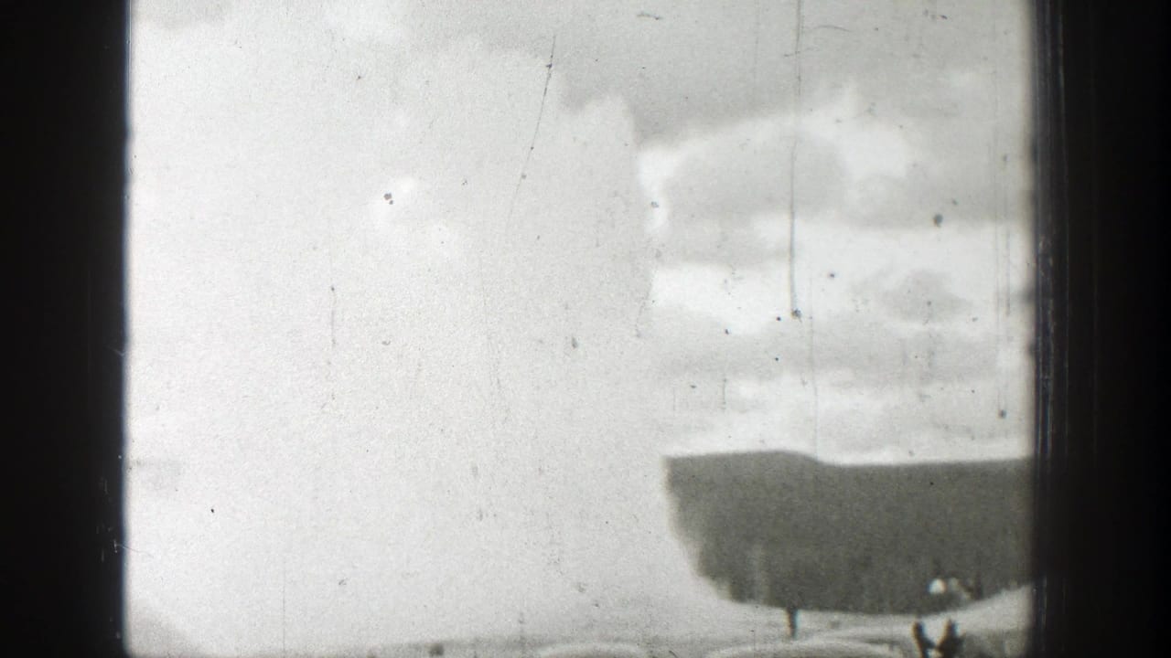 Steam plume and dark landform framed by heavy black film edges.