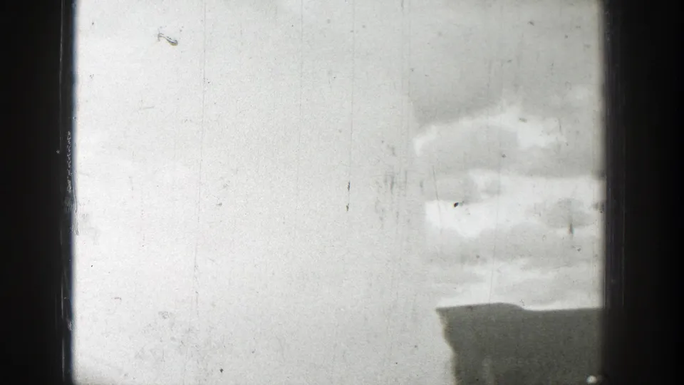 1939 Wyoming 8mm frame with the geyser plume shifted to the right, a low ridge below it, and heavy black border at the side.