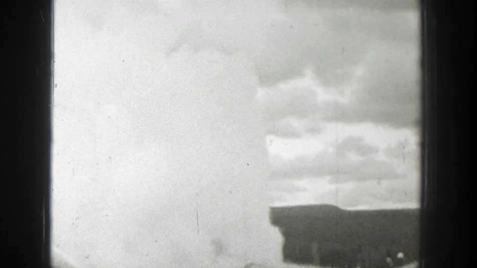 Black-and-white 1939 Wyoming home-movie frame showing cloudy sky, a low roofline, and dark vertical film-frame borders.