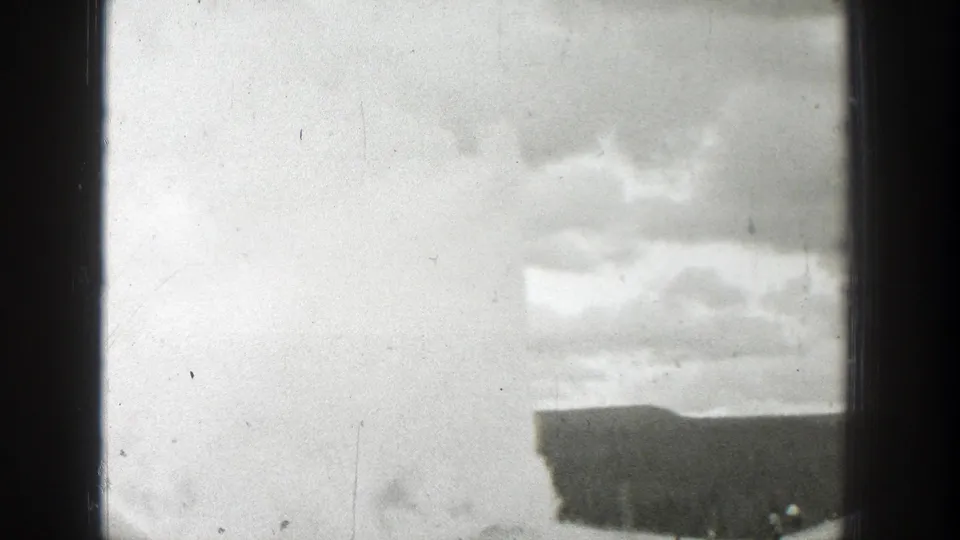 Black-and-white 1939 Wyoming frame with cloudy sky, a low building edge, soft exposure, and visible 8mm contact-sheet borders.