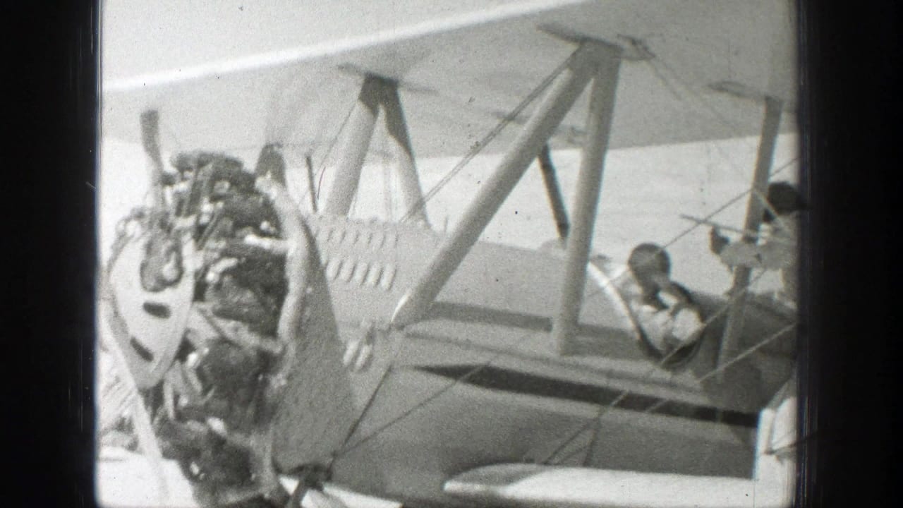 Closer side view of the biplane engine and cockpit with a person inside.