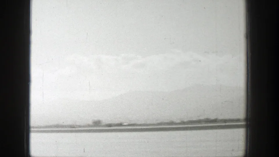 A soft, hazy landscape view appears beyond a flat airfield surface, suggesting a cut away from the aircraft activity to the surrounding Wyoming setting described in the clip metadata.