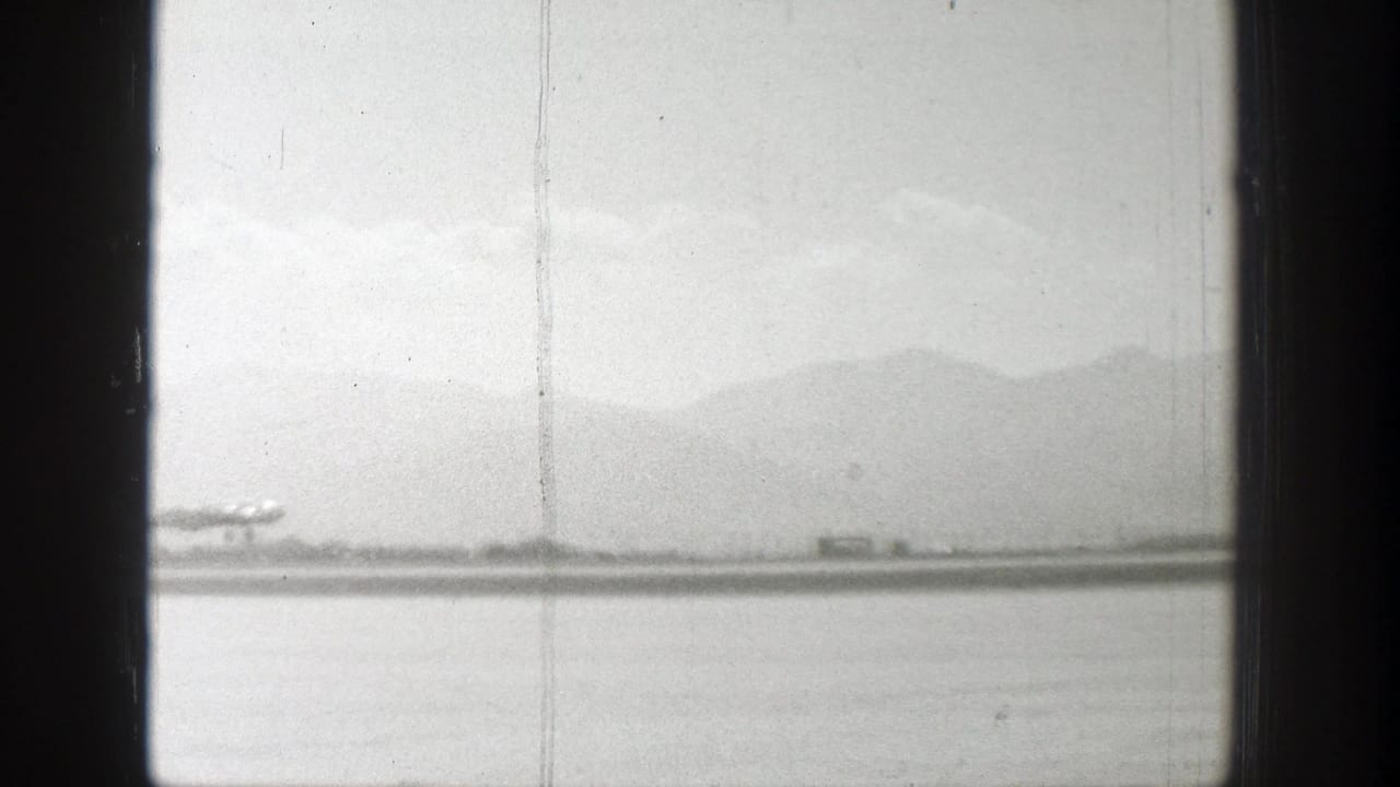 Small plane near the runway with mountains in the background.