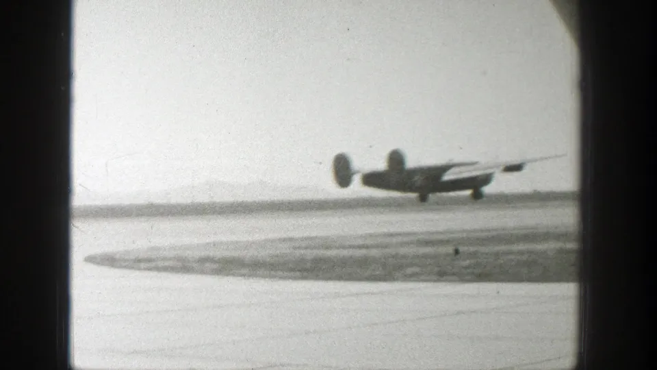 A small propeller airplane is low over the runway or just touching down at a Wyoming airfield in 1939 footage.