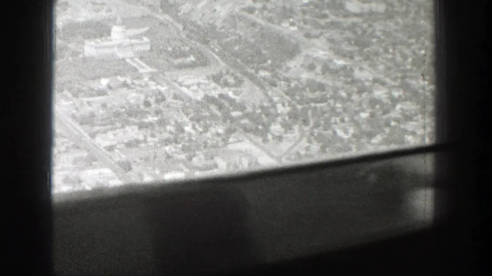 Aerial view over a Wyoming town grid, with roads and clustered buildings seen past dark aircraft window framing.