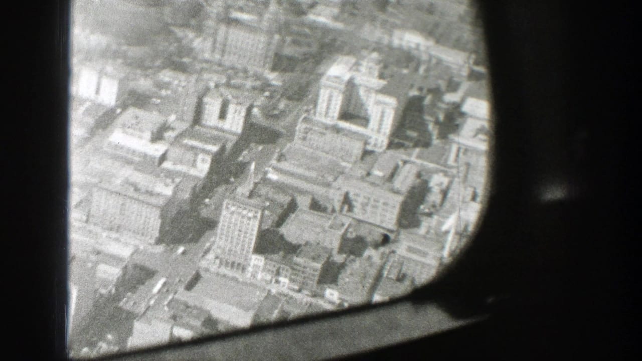 Aerial view of a built-up city area from an airplane, with the window structure cutting across the frame.