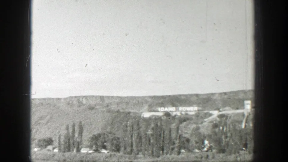 1939 Wyoming home-movie view of a distant hillside, valley trees, road, and Idaho Power lettering near the ridge.