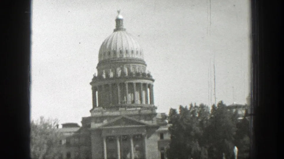 1939 Wyoming 8mm frame showing a domed classical building with columns, roofline detail, trees, and soft black-and-white film texture.