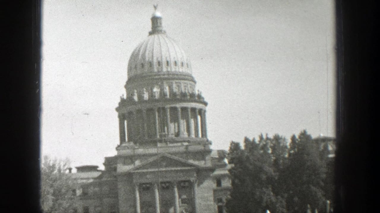 Wyoming State Capitol dome and columned entrance seen through a window frame.